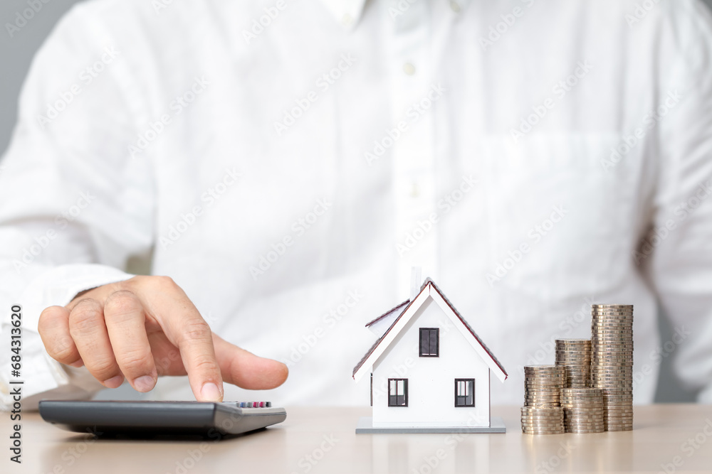 custom made wallpaper toronto digitalBusinessman using a calculator to calculate the cost of building a house and stack gold coin in the office, Loan for real estate or save money for buy a new house to family in the future concept.