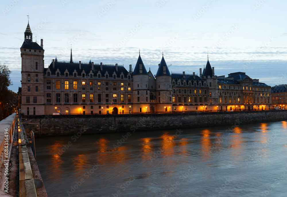 Conciergerie Building in Paris, France at night with lights reflection in the Seine River water . Conciergerie Building in Paris, France at night with lights reflection in the Seine River water .