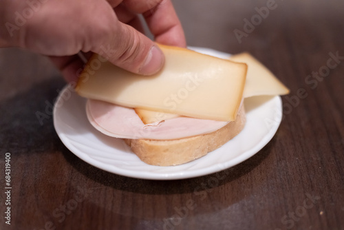 Making a sandwich with sausage and cheese