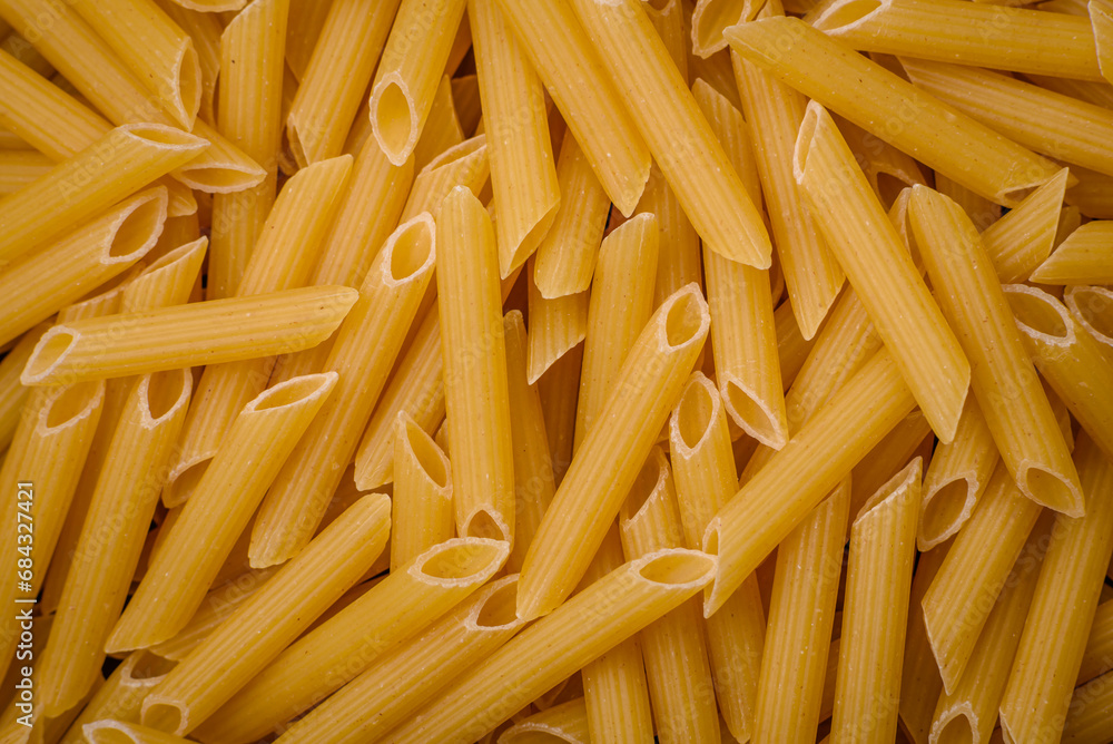 Raw penne pasta from whole grain wheat varieties with salt and spices Raw penne pasta from whole grain wheat varieties with salt and spices