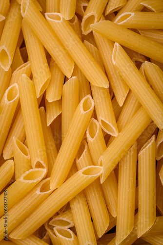 Raw penne pasta from whole grain wheat varieties with salt and spices