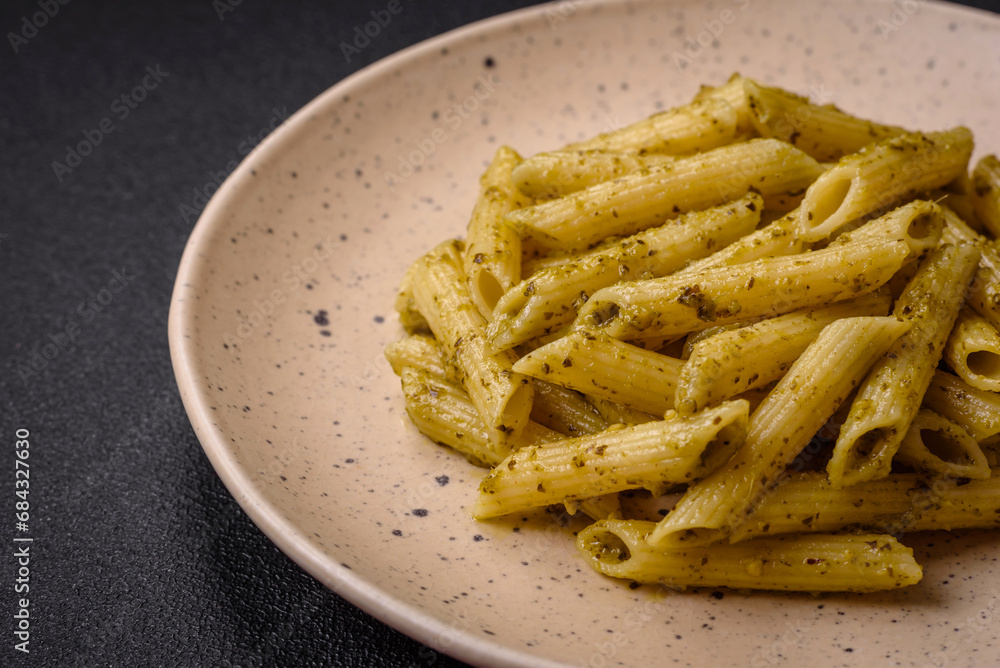 Delicious fresh pasta penne with green pesto sauce with basil, salt and spices