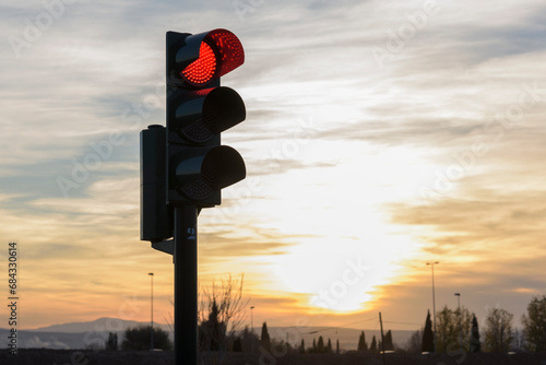 Semáforo de tráfico en rojo con fondo de puesta de sol  photo