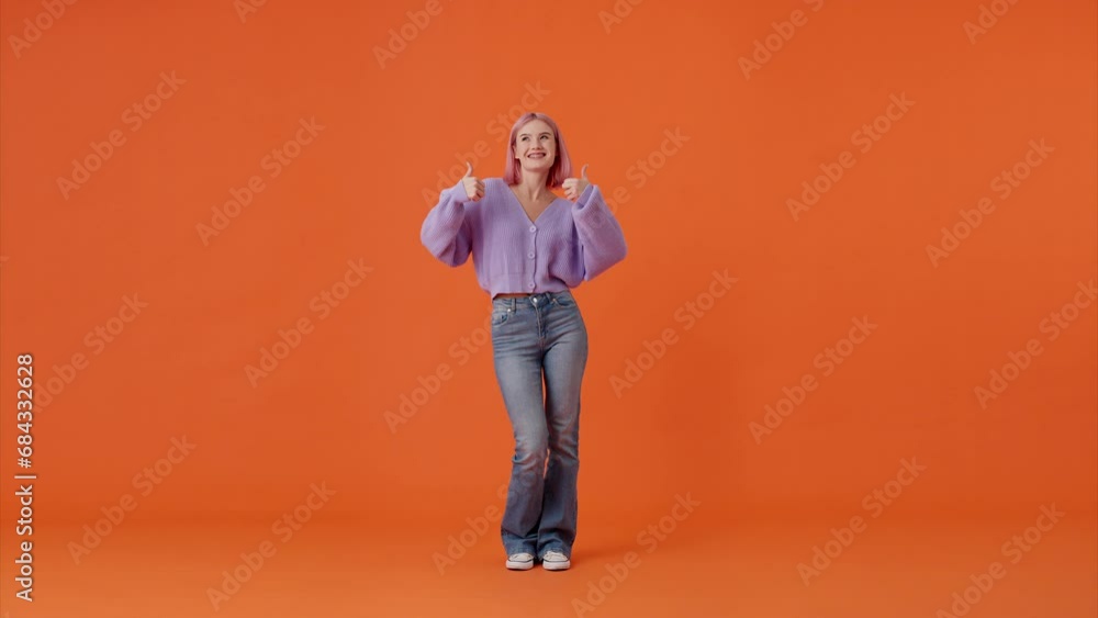 Enthusiastic woman demonstrating thumbs up gesture in studio Enthusiastic woman demonstrating thumbs up gesture in studio