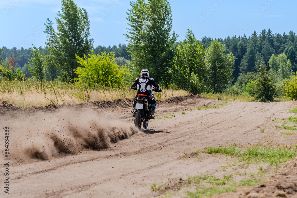 Enduro bike racer riding on dirt motocross road Enduro bike racer riding on dirt motocross road
