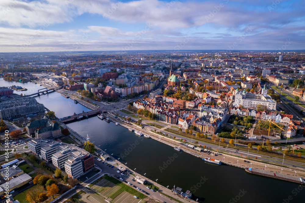Fototapeta premium Szczecin from a bird's eye view on a sunny day. View of the city from the Oder River. City buildings, the seaport in Szczecin and its most characteristic places.