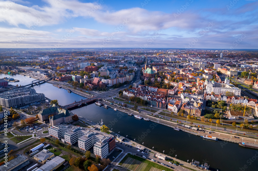 Obraz premium Szczecin from a bird's eye view on a sunny day. View of the city from the Oder River. City buildings, the seaport in Szczecin and its most characteristic places.