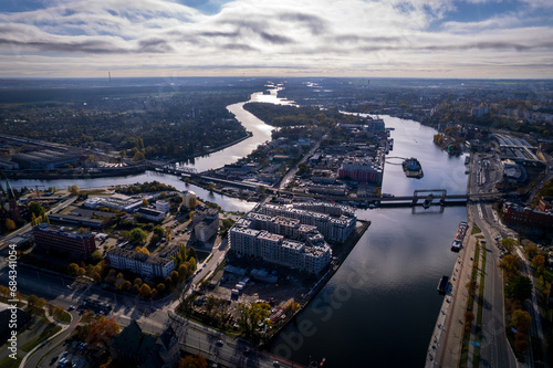 Szczecin from a bird's eye view on a sunny day. View of the city from the Oder River. City buildings, the seaport in Szczecin and its most characteristic places.