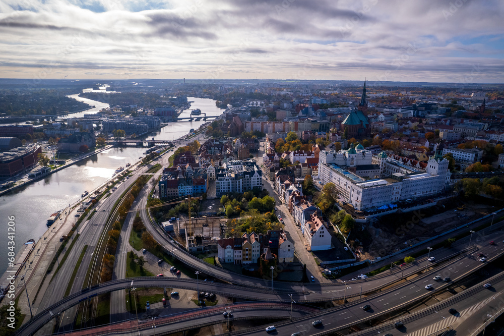 Szczecin from a bird's eye view on a sunny day. View of the city from the Oder River. City buildings, the seaport in Szczecin and its most characteristic places.