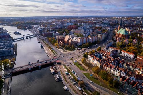 Szczecin from a bird's eye view on a sunny day. View of the city from the Oder River. City buildings, the seaport in Szczecin and its most characteristic places.