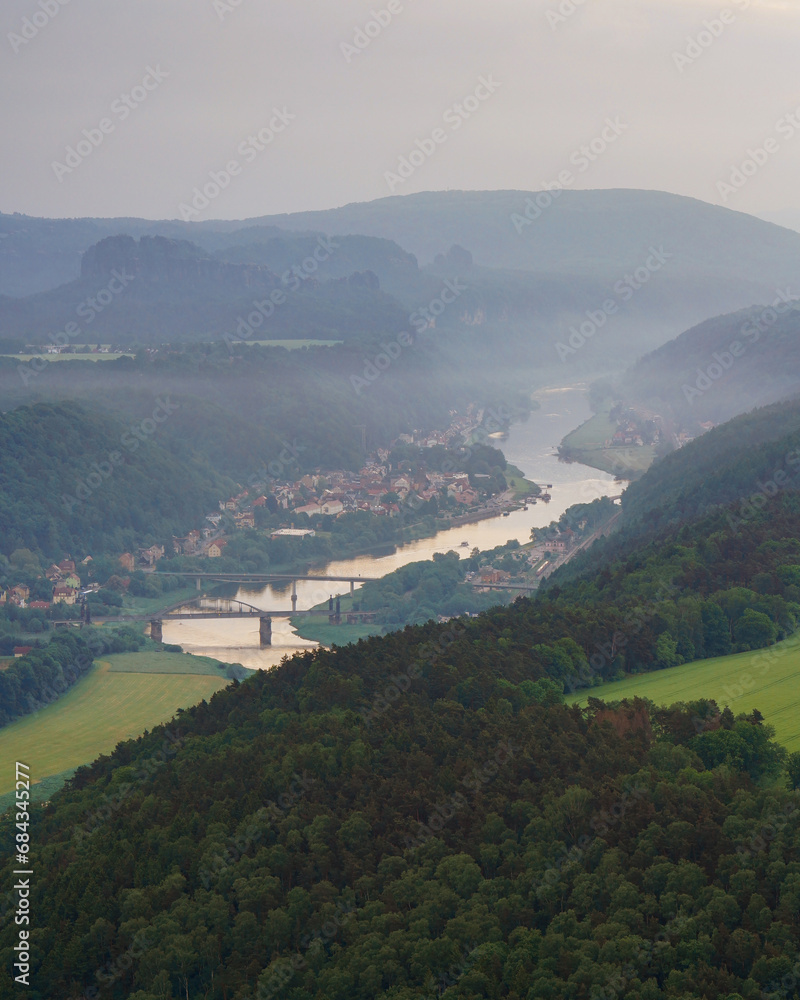Aerial view of Bad Schandau in Saxon Switzerland in the early foggy morning, Carolabrücke bridge on the Elbe river, sandstone rocks and mountains