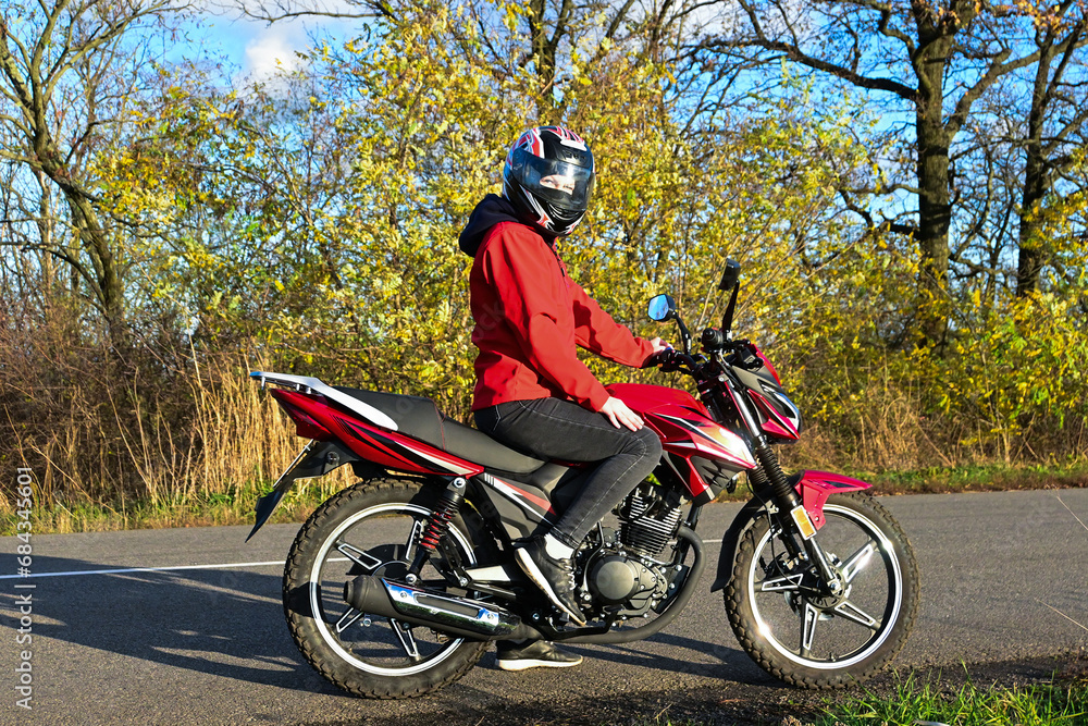 Fototapeta premium biker girl in red. red motorcycle.