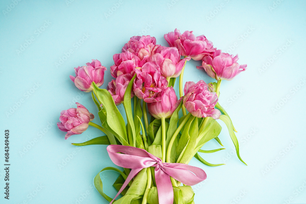 Fresh pink peony tulips on pastel blue background, top view. Festive concept for Mother's Day or Valentines Day.