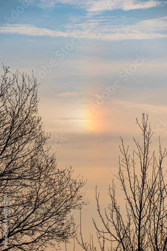 A parhelion  plural parhelia  - atmospheric optical phenomenon that consists of a bright colored spot in the sky. Other names  sun dog  or sundog  or mock sun  halo