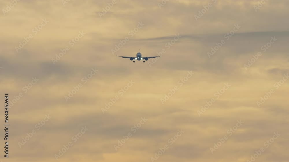 Jet plane approaching to land, descending in the sunset sky. Footage of an airplane flying in the sky, front view. Tourism and travel concept. Aircraft arriving Jet plane approaching to land, descending in the sunset sky. Footage of an airplane flying in the sky, front view. Tourism and travel concept. Aircraft arriving