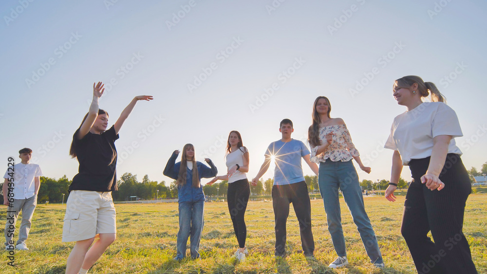 Funny jolly friends dancing in the city meadow in the evening. Funny jolly friends dancing in the city meadow in the evening.