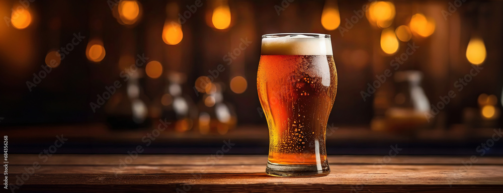 A glass of dark beer on wooden table with dark golden shiny garland background. Panorama with copy space. - obrazy, fototapety, plakaty 