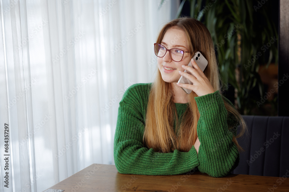 girl talking on a mobile phone at a table in a cafe girl talking on a mobile phone at a table in a cafe