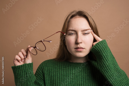 woman with poor vision on a isolated beige background, health problems astigmatism myopia, Poor vision concept
