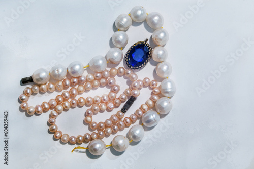 2 chains of large white ands small pink pearls and blue glass