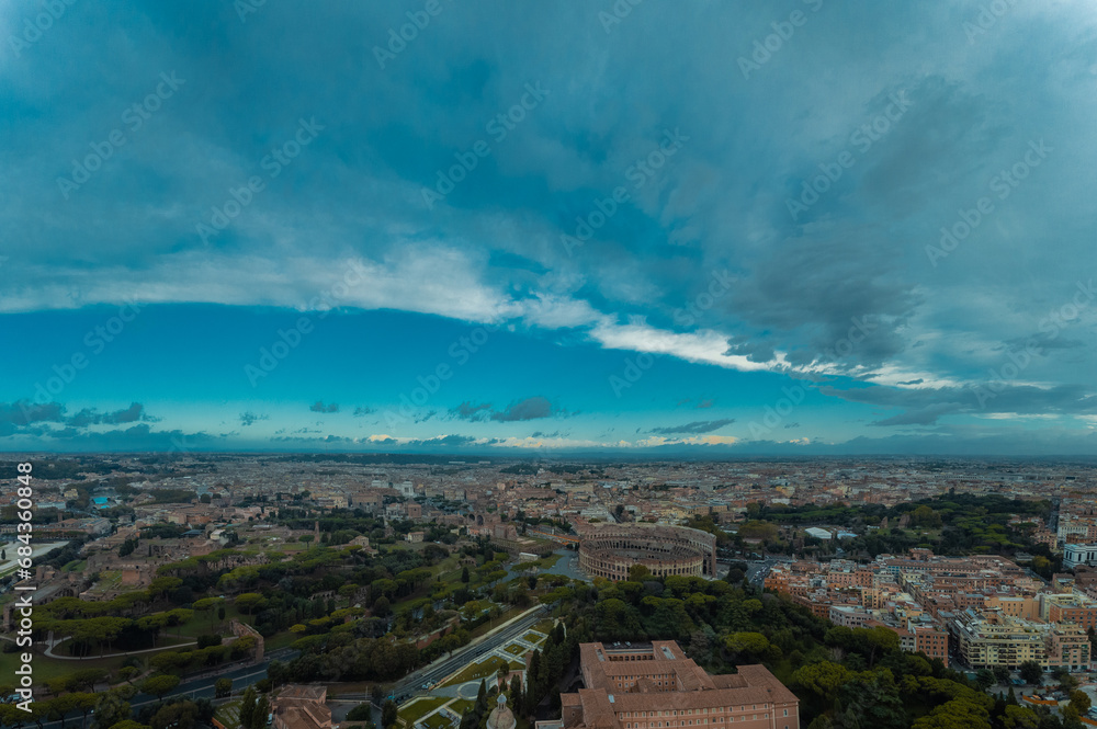 Fototapeta premium Aerial drone view of Colosseum in rome on an autumn morning, wiewed from the south gardens. Epic sky above the colosseum, famous monument in the central italy.