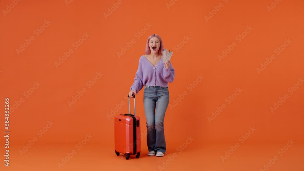 Excited woman holding tickets and red suitcase in studio Excited woman holding tickets and red suitcase in studio