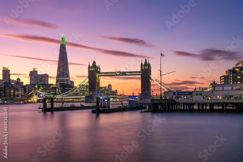 a beautiful sunset view of a large city over water in london © Wirestock