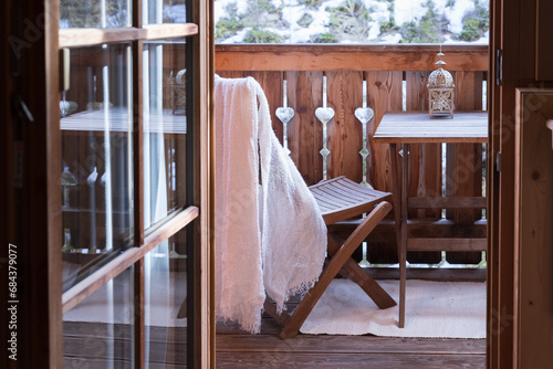 An open door to a small wooden balcony with nature views, wooden furniture and all the decoration create a cozy home