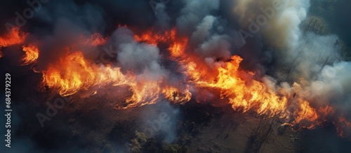 Aerial top view of a forest fire, burning grass with smoke and fire. © 2rogan