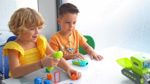 Caucasian children relaxing enjoying hobby playing with toy car remote control point in white classroom . Preschoolers kids learning radio-controlled car.