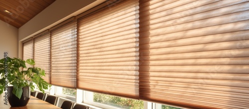 Closing cellular shades indoors with honeycomb blind curtain for energy efficiency in modern home decor.