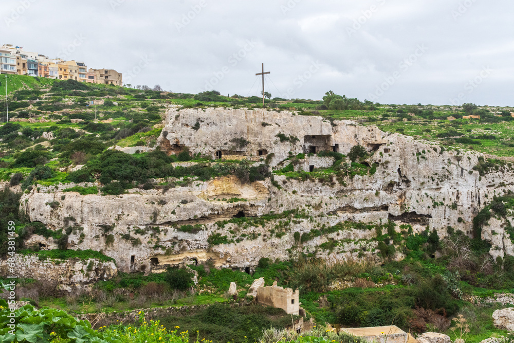 Mellieħa, Malta - December 24th 2022: The Mellieha Cave dwellings built into the cliff overlooked the valley.