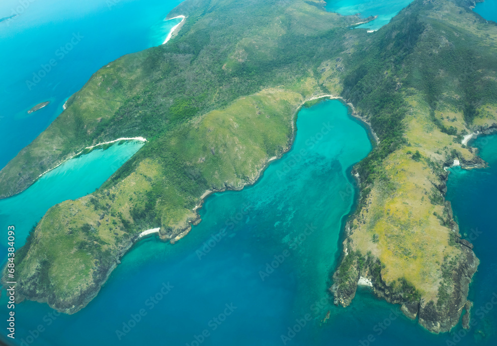 Aerial view of part of the Whitsunday Island at Great Barrier Reef. The blue waters are deeper than green waters. The reef is located in the Coral Sea, off the coast of Queensland, Australia. Dec 2019