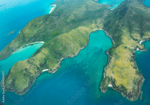 Aerial view of part of the Whitsunday Island at Great Barrier Reef. The blue waters are deeper than green waters. The reef is located in the Coral Sea, off the coast of Queensland, Australia. Dec 2019