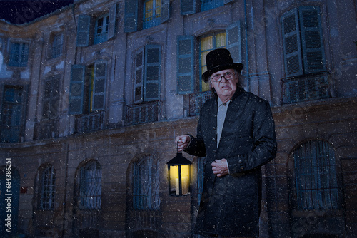 Scrooge walking in the street with a lantern, under snow and a moonlight