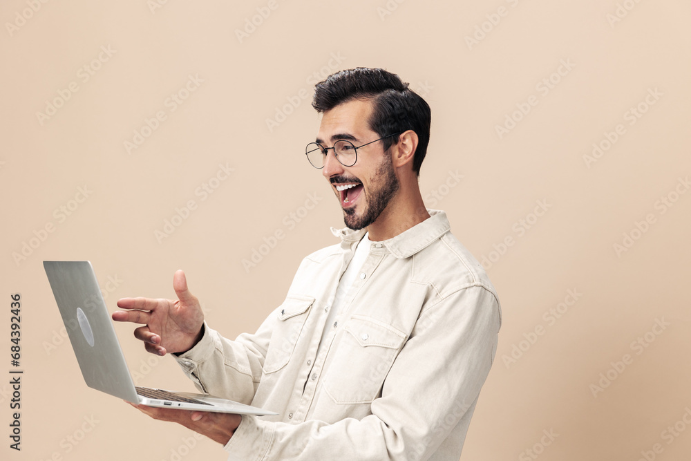 Portrait of a stylish with a laptop in his hands mockup, working freelancer smile with teeth open mouth slavery victory, beige background in a white t-shirt, fashionable clothing style, space space Portrait of a stylish with a laptop in his hands mockup, working freelancer smile with teeth open mouth slavery victory, beige background in a white t-shirt, fashionable clothing style, space space