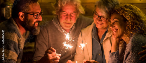 group of people celebrating the 2021 new year after a hard 2020 - bye 2020 concept - family enjoying and having fun together with sparklers at home eating pizza at dinner - christimas concept