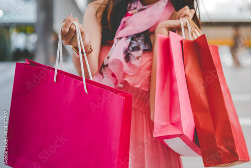 Shopaholic Women holding shopping bags ,money ,credit card person at shopping malls.Fashionable Woman love online website with sales tag on black Friday. E-commerce fashion digital marketing lifestyle photo