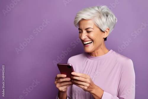 Joyful Senior Woman with Silver Hair Using Smartphone on Purple Background