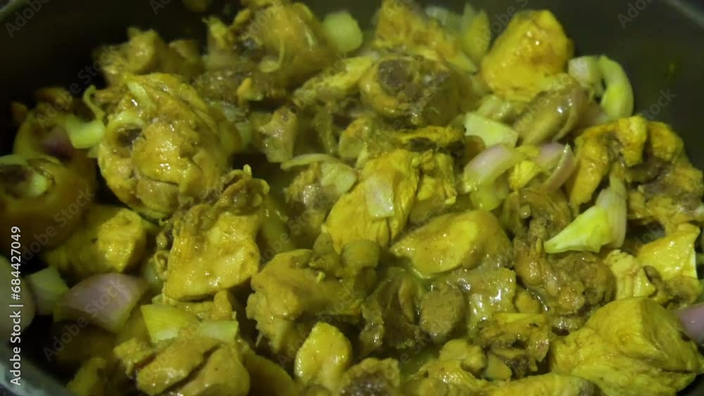Cooking chopped up chicken meat with onions and spices in oil Cooking chopped up chicken meat with onions and spices in oil