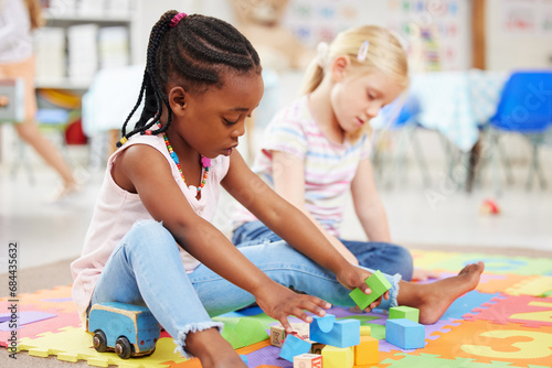 Education, kindergarten and children with toys for playing, child development and creative learning. School, youth and young girls with building blocks for fun, relax and educational games on floor