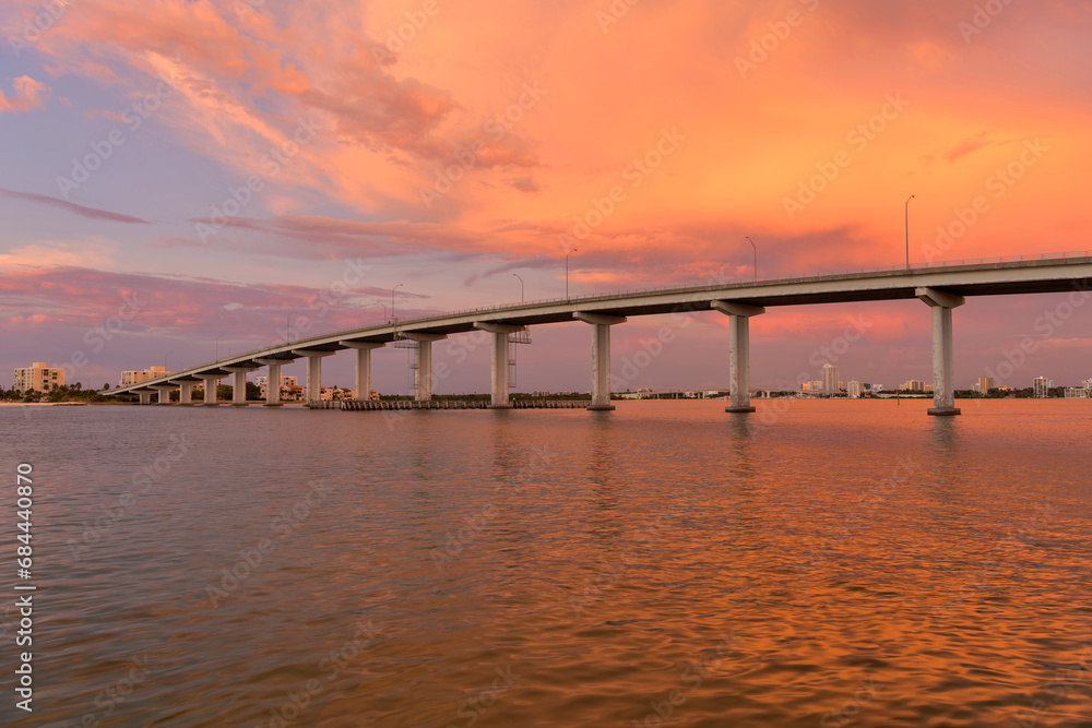 Sunset Bridge - A colorful sunset view of Sand Key Bridge, a girder bridge connecting Clearwater and Belleair Beach over the Clearwater Pass, Florida, USA. Sunset Bridge - A colorful sunset view of Sand Key Bridge, a girder bridge connecting Clearwater and Belleair Beach over the Clearwater Pass, Florida, USA.
