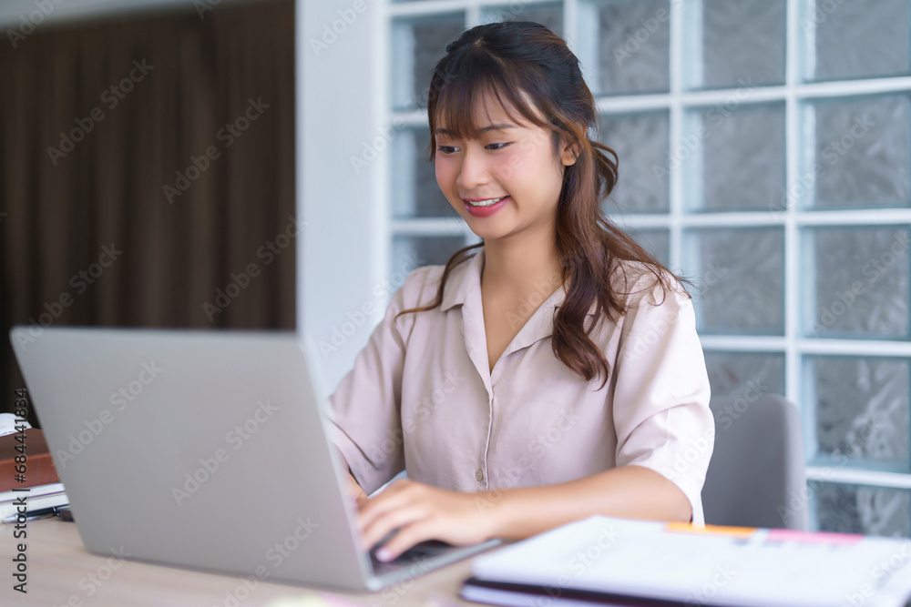 Young asian student in casual clothes watching tutorial and studying lecturer education online class while typing knowledge data and working homework with laptop digital technology in university Young asian student in casual clothes watching tutorial and studying lecturer education online class while typing knowledge data and working homework with laptop digital technology in university