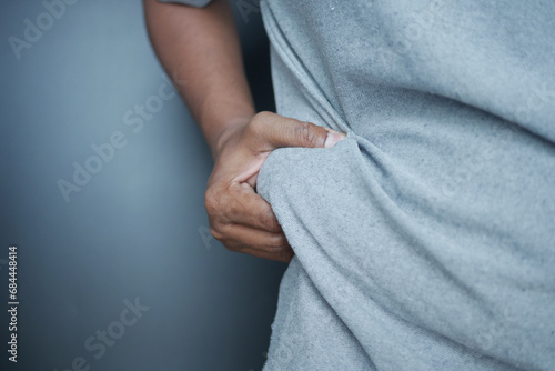 man's hand holding excessive belly fat, overweight concept