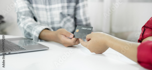 E-commerce Concept. Happy couple holding credit card enjoying doing online shopping and using laptop enter their card number in-app to purchase and payment in the internet store © Orathai