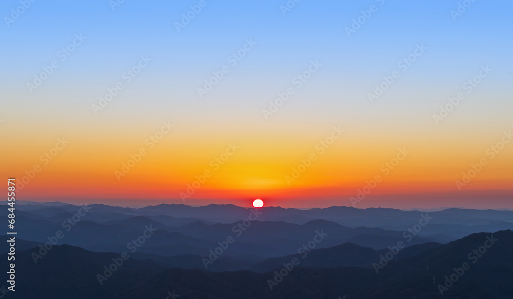 A view of the sun setting over the mountains. sunset