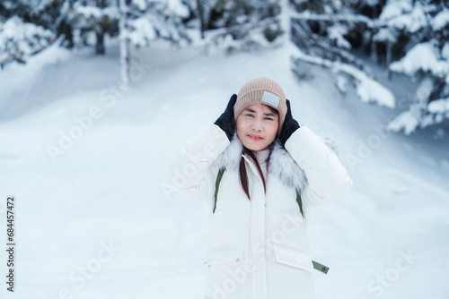 happy Traveler with Sweater and backpack walking on snow covered forest in frosty weather. Winter Travel, Adventure, Exploring and Vacation concept