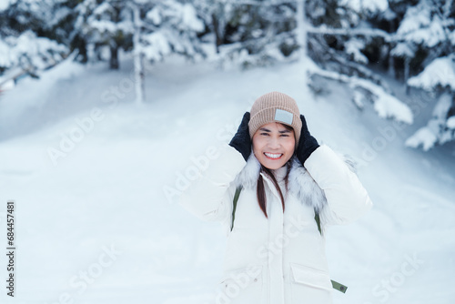 happy Traveler with Sweater and backpack walking on snow covered forest in frosty weather. Winter Travel, Adventure, Exploring and Vacation concept