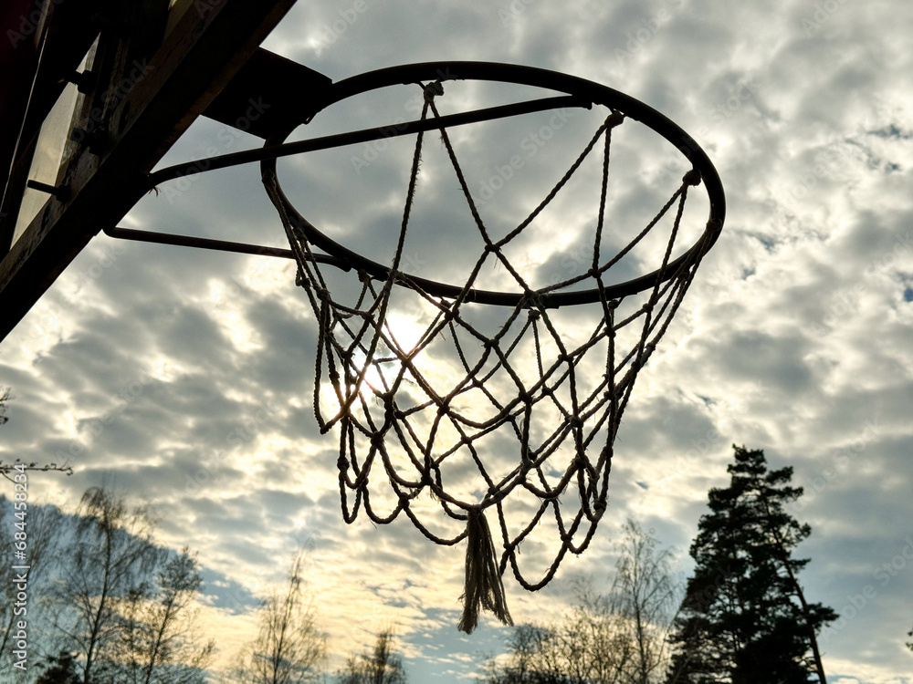 Basketball hoop against the background of the sky with clouds