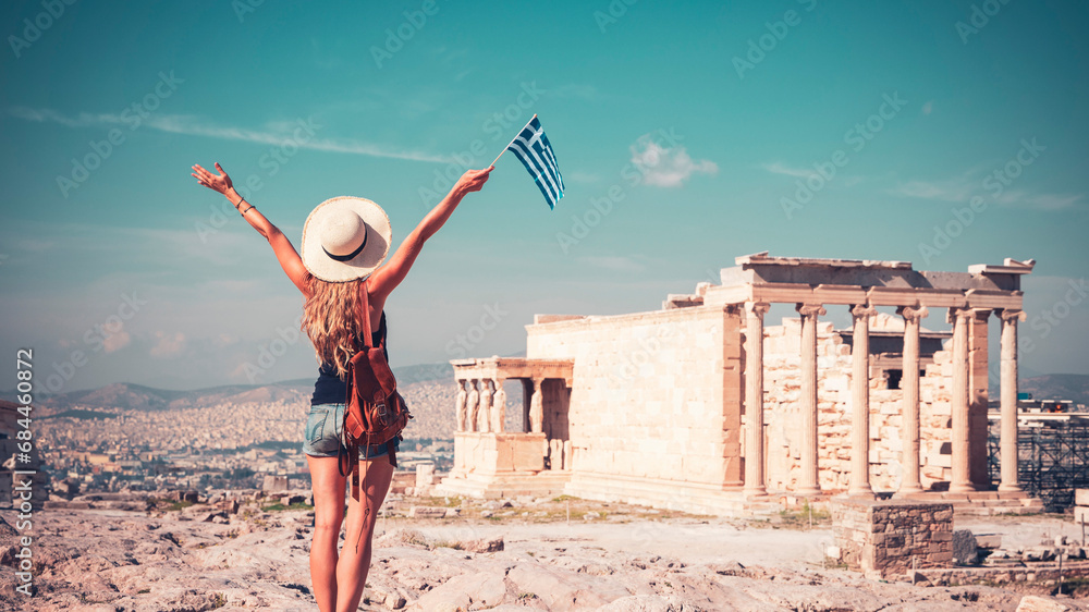 Fototapeta premium Traveler young female with hat, bag and Greek flag in Athens, Acropolis